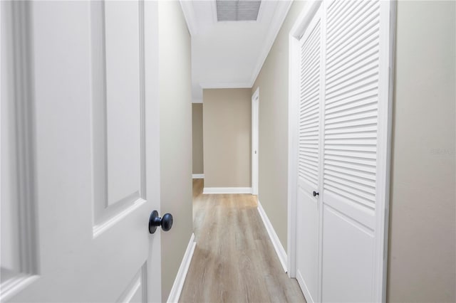 corridor featuring light hardwood / wood-style floors and crown molding