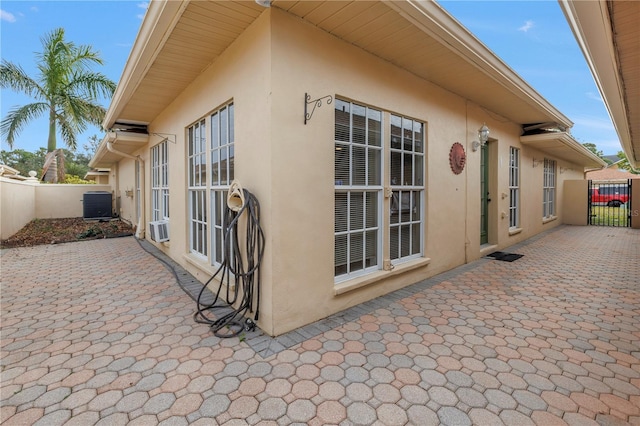 view of side of home with a patio area and central air condition unit