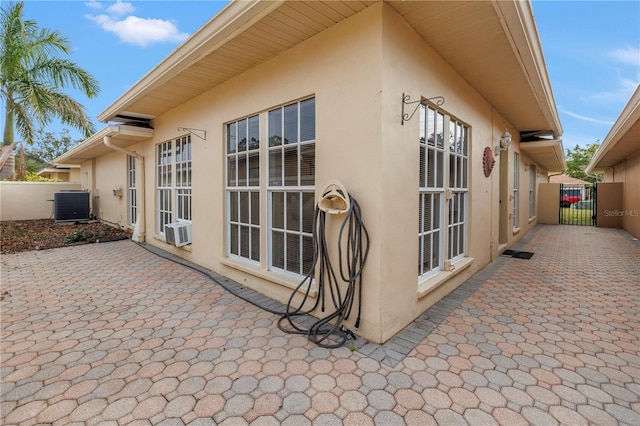 view of property exterior featuring central AC unit, cooling unit, and a patio