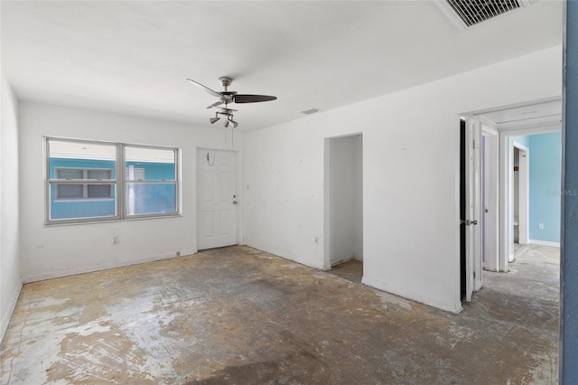 empty room with a ceiling fan and unfinished concrete flooring