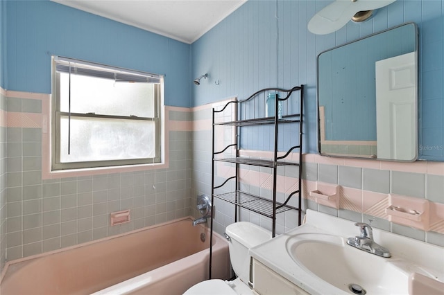 bathroom featuring toilet, shower / bathtub combination, vanity, tile walls, and crown molding