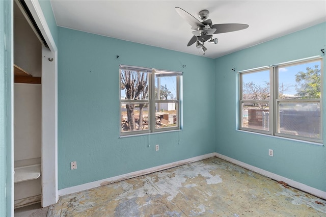 unfurnished bedroom featuring multiple windows, baseboards, and a ceiling fan