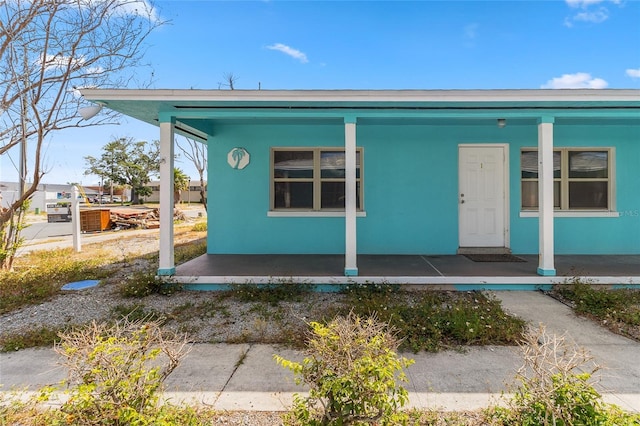 bungalow-style home with covered porch and stucco siding