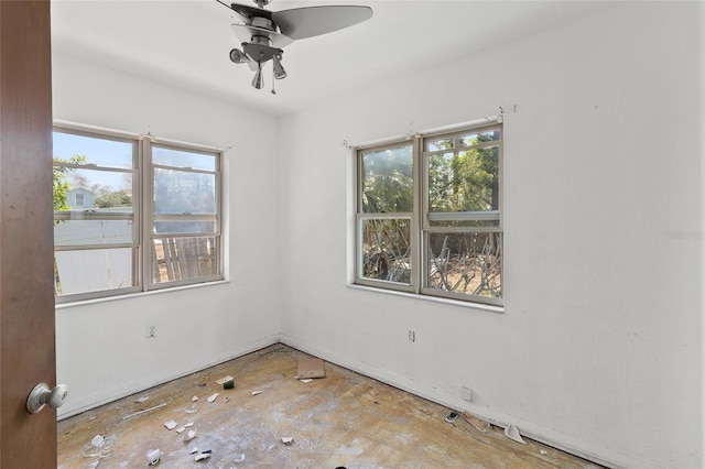 unfurnished room featuring plenty of natural light, ceiling fan, and baseboards
