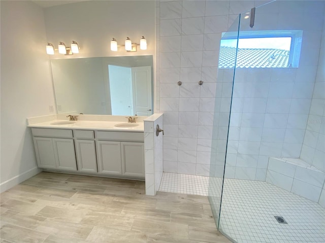 bathroom with vanity and a tile shower