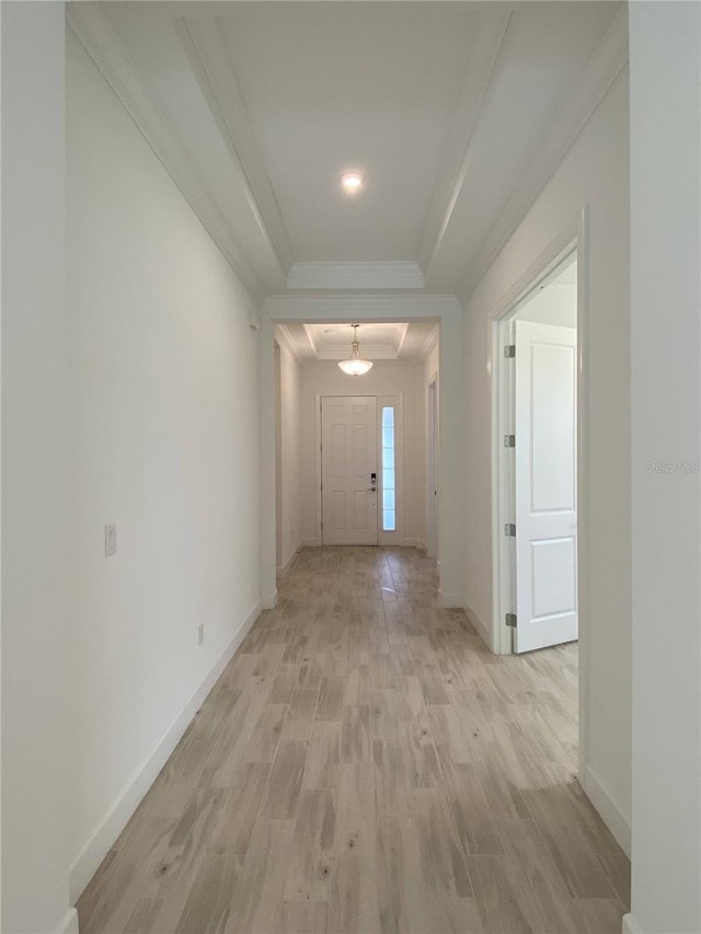 hallway with light hardwood / wood-style floors and ornamental molding