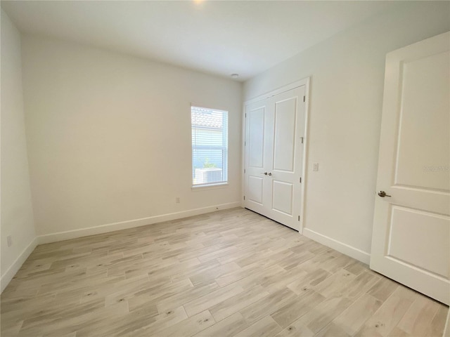 unfurnished bedroom with light hardwood / wood-style floors and a closet