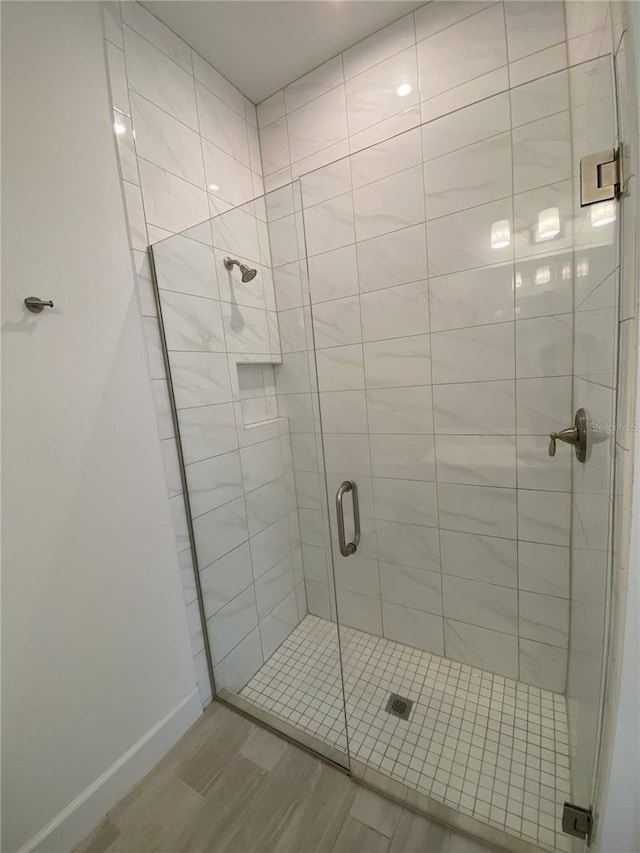 bathroom featuring a shower with door and hardwood / wood-style floors