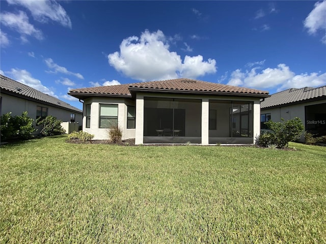 rear view of property with a yard and a sunroom