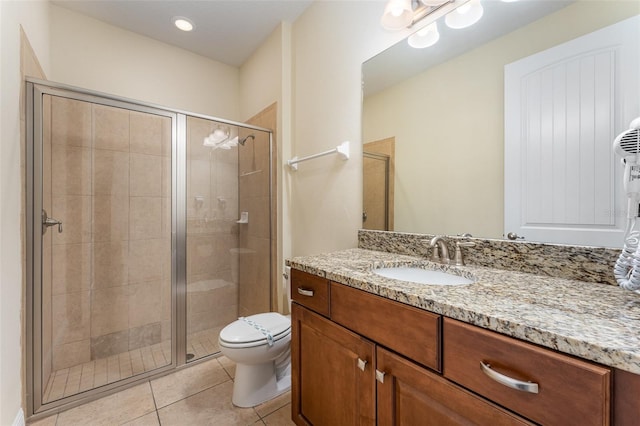 bathroom with toilet, vanity, tile patterned floors, and an enclosed shower