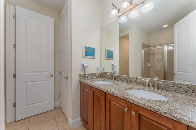 bathroom featuring tile patterned floors, vanity, and a shower with door