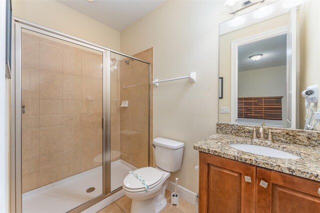 bathroom featuring toilet, vanity, tile patterned floors, and walk in shower