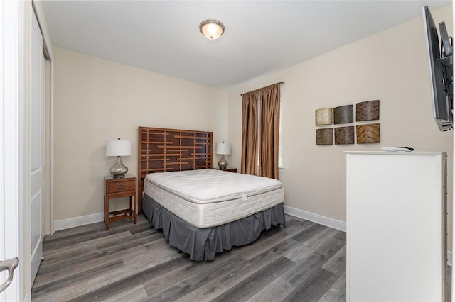 bedroom with dark hardwood / wood-style flooring and a closet