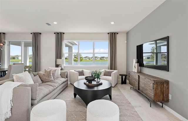 living room with a water view and a healthy amount of sunlight