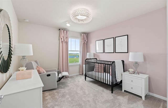 bedroom with a nursery area and light carpet