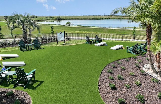 view of property's community with a lawn and a water view