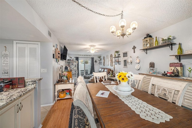 dining area featuring ceiling fan with notable chandelier, light hardwood / wood-style floors, and a textured ceiling