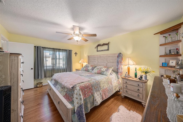 bedroom featuring ceiling fan, a textured ceiling, and hardwood / wood-style flooring