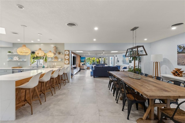 dining area featuring a textured ceiling and sink