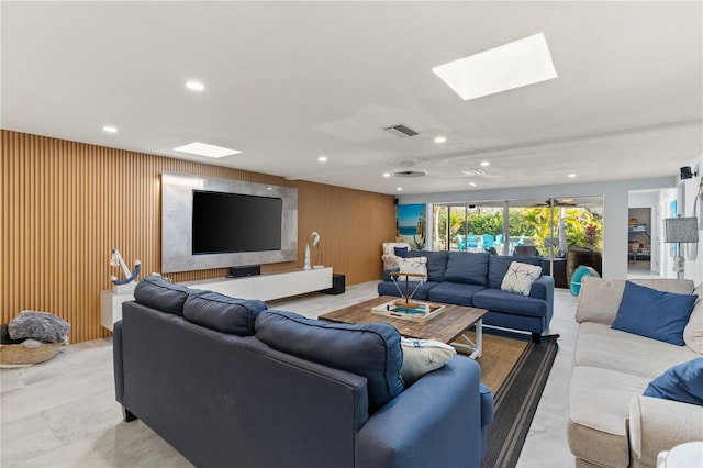 living room with ceiling fan and wooden walls