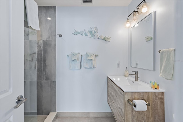 bathroom with tile patterned flooring, walk in shower, and vanity