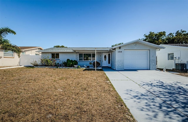 single story home featuring a front lawn, a garage, and central AC unit