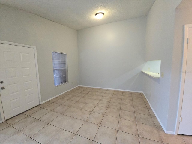 spare room with light tile patterned floors and a textured ceiling