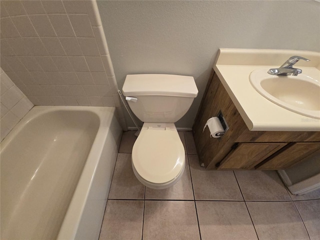 bathroom with tile patterned flooring, vanity, toilet, and a washtub