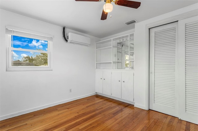 8716 Hickorywood Ln, Tampa, FL 33615 - unfurnished bedroom featuring visible vents, a closet, baseboards, an AC wall unit, and light wood-type flooring