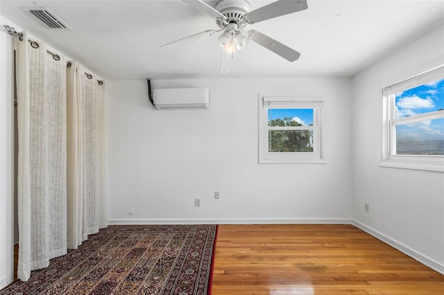 8716 Hickorywood Ln, Tampa, FL 33615 - spare room featuring baseboards, a wall mounted AC, wood finished floors, and visible vents