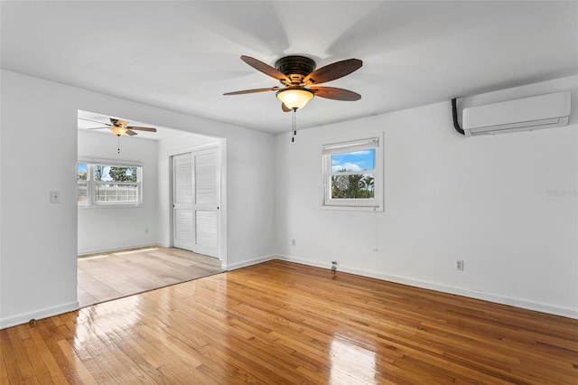 8716 Hickorywood Ln, Tampa, FL 33615 - unfurnished room featuring an AC wall unit, ceiling fan, and light wood-style floors