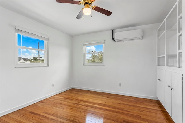 8716 Hickorywood Ln, Tampa, FL 33615 - spare room with baseboards, a wall mounted AC, a ceiling fan, and light wood-type flooring