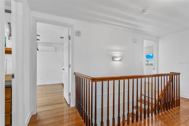 8716 Hickorywood Ln, Tampa, FL 33615 - hallway with baseboards, an upstairs landing, a wall unit AC, and wood finished floors