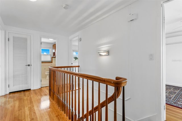 8716 Hickorywood Ln, Tampa, FL 33615 - hallway featuring baseboards, light wood finished floors, and an upstairs landing