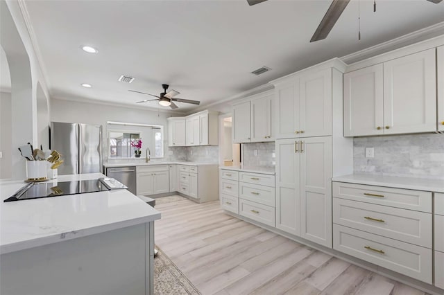 8716 Hickorywood Ln, Tampa, FL 33615 - kitchen featuring crown molding, ceiling fan, light countertops, backsplash, and stainless steel appliances