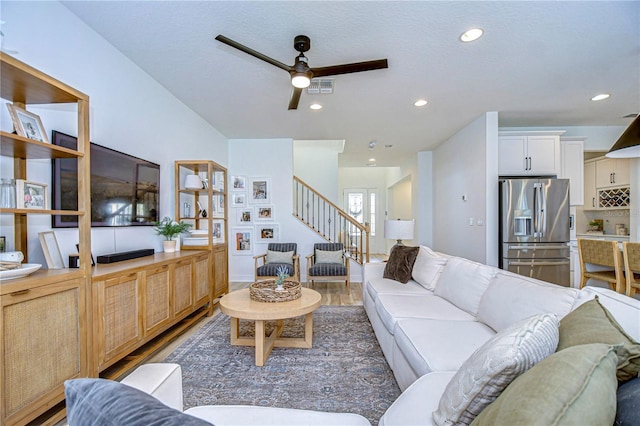 living room featuring ceiling fan, a textured ceiling, and hardwood / wood-style flooring