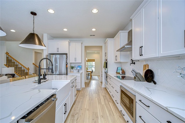 kitchen with white cabinets, stainless steel appliances, and decorative light fixtures