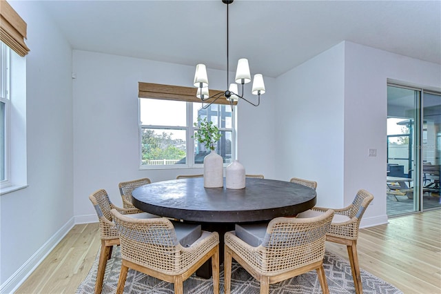 dining room featuring light wood-type flooring and an inviting chandelier