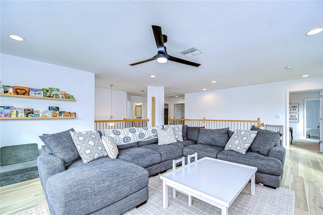 living room with ceiling fan and light hardwood / wood-style floors