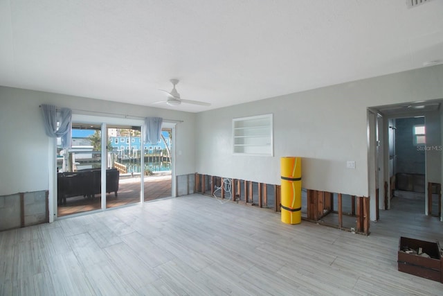 unfurnished room featuring ceiling fan, built in features, and light hardwood / wood-style floors