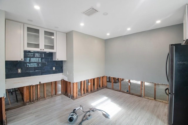 kitchen featuring white cabinetry, stainless steel refrigerator, and light hardwood / wood-style flooring