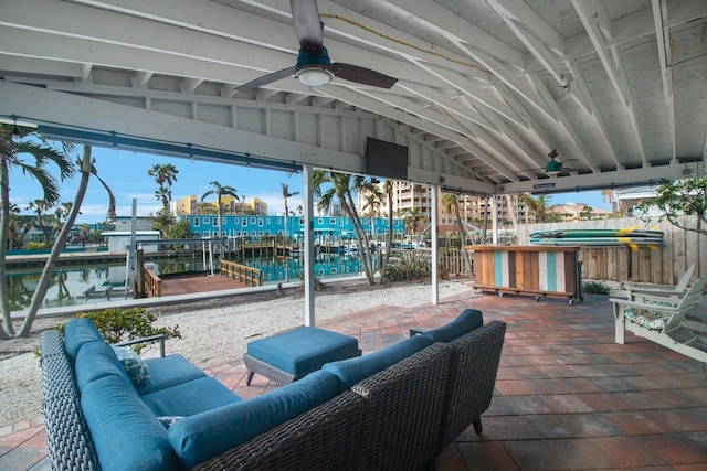 view of patio with ceiling fan, a water view, an outdoor hangout area, and a boat dock