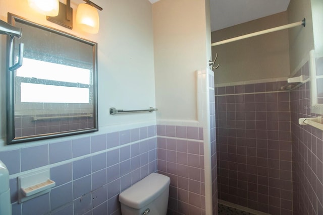 bathroom with walk in shower, toilet, and tile walls