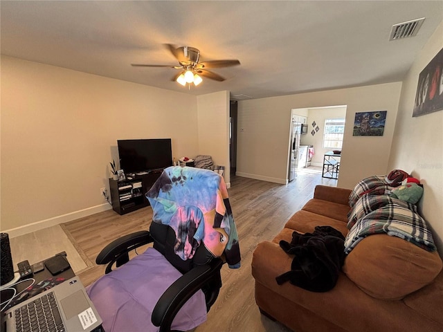 living room featuring ceiling fan and light hardwood / wood-style floors