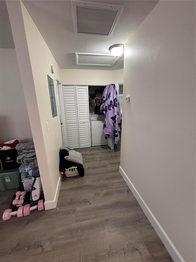 corridor with hardwood / wood-style floors and washer / dryer