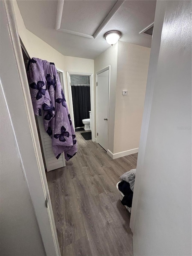 hallway featuring hardwood / wood-style floors and a textured ceiling