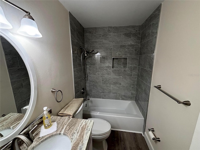 full bathroom with tiled shower / bath combo, toilet, wood-type flooring, and vanity