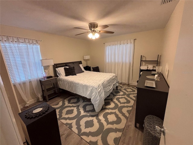 bedroom with ceiling fan and dark wood-type flooring