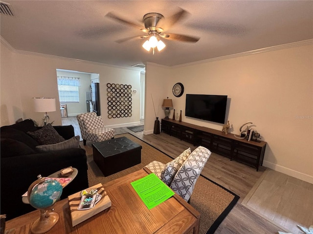 living room featuring a textured ceiling, hardwood / wood-style flooring, ceiling fan, and crown molding