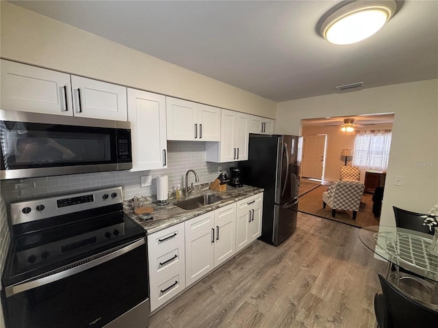 kitchen featuring white cabinets, stainless steel appliances, and sink